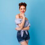 charming-female-model-trendy-blouse-looking-camera-well-dressed-pinup-girl-standing-blue-space