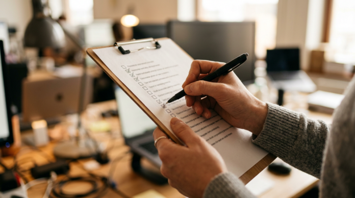 Business SOP चेकलिस्ट पर टिक करते हाथ